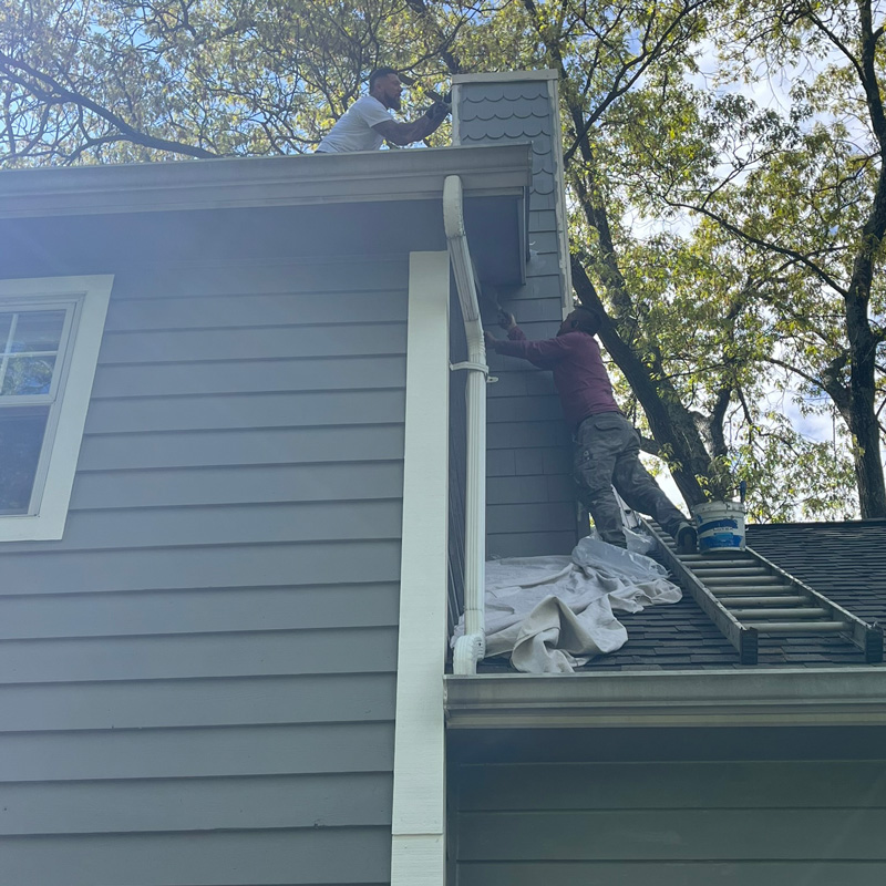 two men painting a house